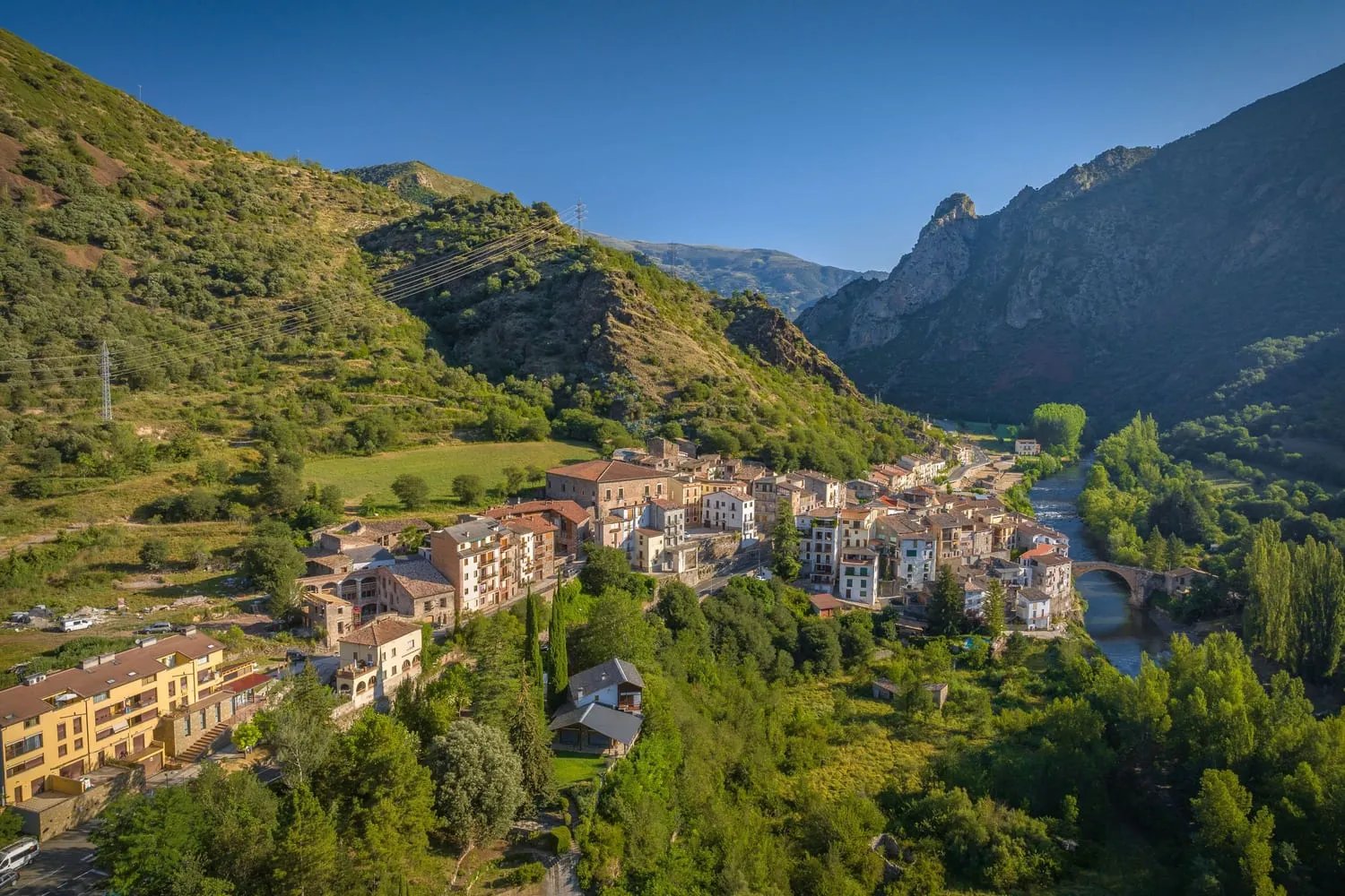 Vista aèria d'un nucli del Baix Pallars vora el riu, entre muntanyes